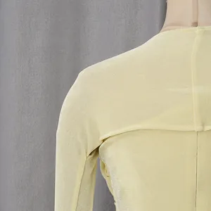 Macro close-up showing the fine texture of a yellow elegant dress shoulder and neckline