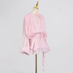 Detail view of pink pleated mini dress with elegant tie-neck and ruffled hem.
