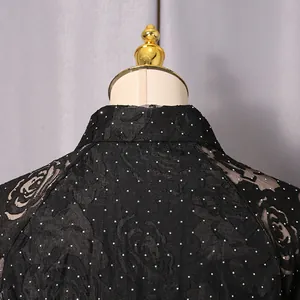 Close-up detail of black floral printed dress with sparkling rhinestones on collar