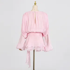 Back view of a sweet pink pleated short dress with waist tie and round neck on a mannequin