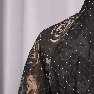 Detailed view of elegant black floral printed lace dress with sparkling silver rhinestones.
