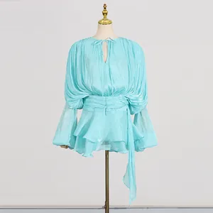Detailed view of light blue pleated mini dress with tie-neck and puffed long sleeves.
