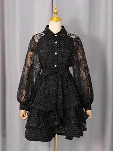 Elegant black polka dot lace dress featuring tie-waist design and layered ruffled hem details