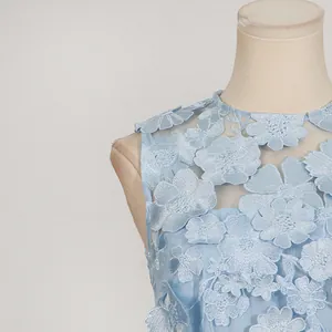 Primo piano di un abito senza maniche celeste con applicazioni floreali 3D sullo scollo