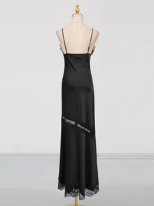 Elegant black satin slip maxi dress with intricate lace trim and diagonal stitching detail.
