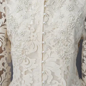 Gros plan détaillé d'une robe en dentelle beige élégante avec broderies de perles
