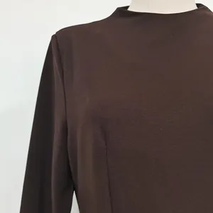 Close-up of the mock neck and smooth fabric texture on a brown long sleeve dress