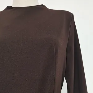 Close-up of elegant dark brown long-sleeved dress showing fabric texture and mock neck