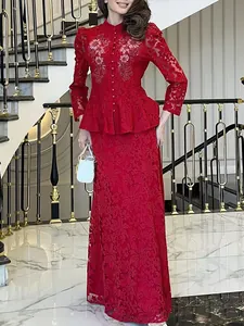 Ensemble jupe deux pièces en dentelle rouge élégante avec haut à basque et jupe longue.