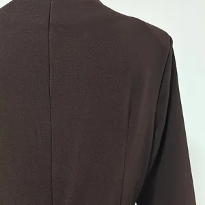 Close-up detail of the premium brown woven fabric texture on an elegant slim fit dress.