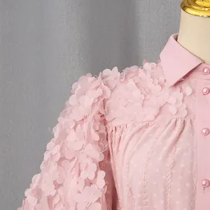 Dettaglio di abito bohémien rosa con squisita applicazione floreale 3D sulla spalla