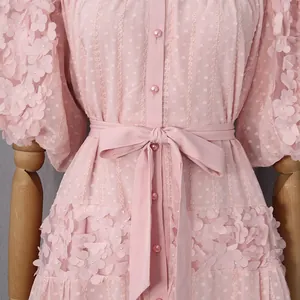Dettaglio di un abito boho rosa con applicazioni floreali 3D e cintura in vita
