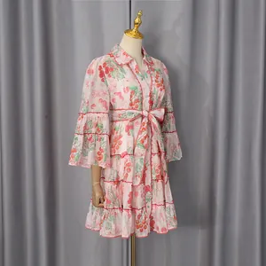 Detailed view of a pink French-style cherry print shirt dress with tiered skirt