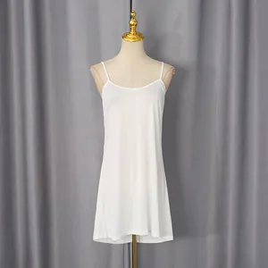 Detail of a white sleeveless camisole slip dress on a mannequin with grey curtain background