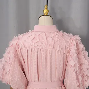 Vista dettagliata di un abito bohémien rosa con elaborate applicazioni floreali
