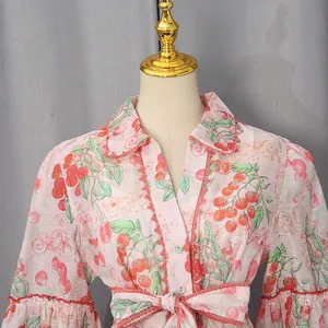 Detailed macro view of French style pink floral shirt dress with fruit print and bow
