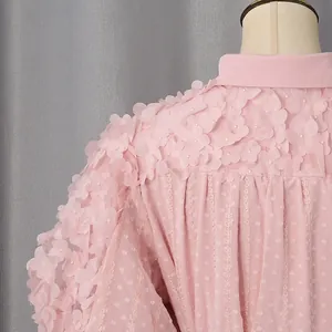 Dettaglio abito bohémien rosa con applicazioni floreali 3D e tessuto testurizzato a pois