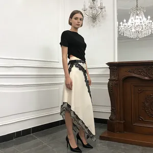 Elegant asymmetrical white dress with black lace trim and sexy waist cutout detail