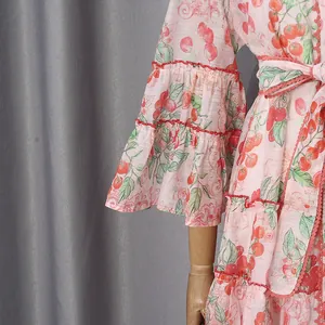 Macro detail view of the ruffled bell sleeves and tomato pattern on a French shirt dress.
