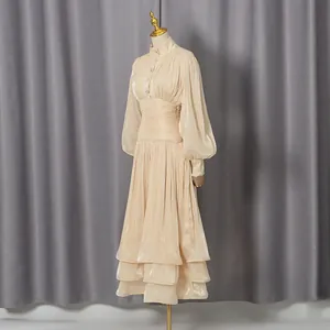 Elegant French champagne pleated dress with lantern sleeves and layered skirt detail.