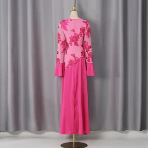 Dettaglio posteriore di un abito lungo rosa a maniche lunghe con patchwork in pizzo floreale.