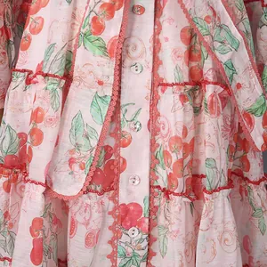 Macro detail view of floral fruit print fabric on a tiered French style shirt dress.