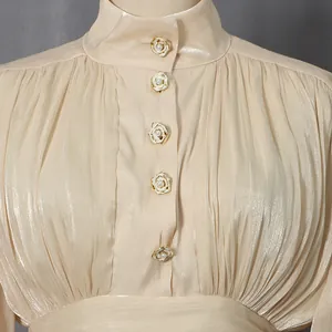 Detailed macro view of the rose buttons and pleated champagne fabric of an elegant dress