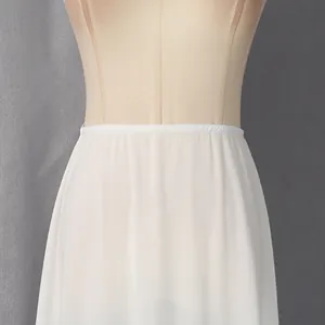 Detail van de tailleband van een witte semi-transparante zomerrok op een etalagepop