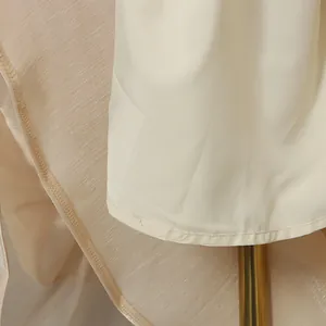 Macro detail showing the refined hemline and premium lining of this elegant beige evening dress