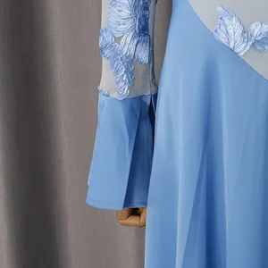 Dettaglio dell'eccellente ricamo floreale blu e della manica a rete di questo abito lungo