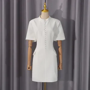 Elegante vestido corto blanco de manga corta con botones en un maniquí profesional