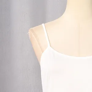 Close-up detail showing the thin shoulder strap and neckline of a white French style dress.
