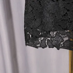 Detailed close-up view of the intricate black floral hollow lace texture on this dress
