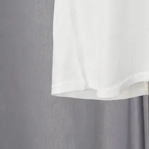 Detailed close-up showing the high-quality stitching on the hem of this white shirt dress.