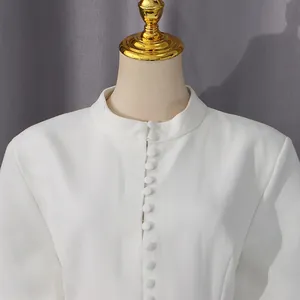 Primer plano de vestido blanco de estilo francés con botones y cuello alto