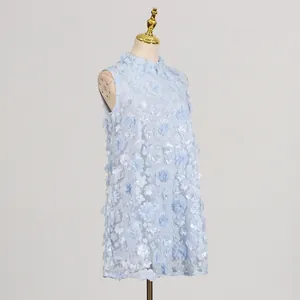 Detailed side view of light blue sleeveless dress with 3D floral appliqués and pearls.
