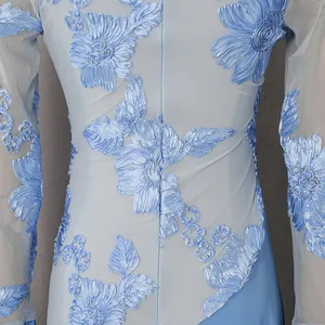 Dettaglio dell'elegante ricamo floreale azzurro su abito a maniche lunghe in rete