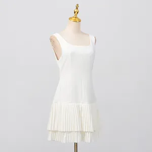 Elegante vestido mini blanco sin mangas con dobladillo plisado, mostrado en un maniquí.