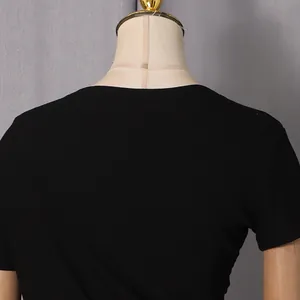 Close-up detail of the neckline and ribbed fabric of a black short-sleeved dress on a mannequin