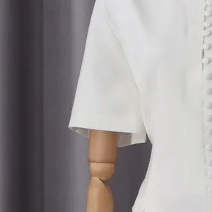Detalle de vestido blanco de estilo francés con elegantes botones y textura de tela suave