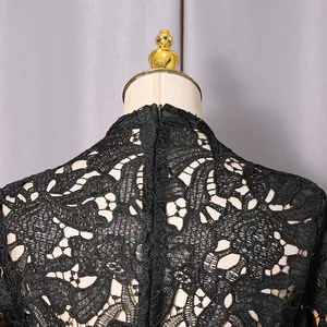 Close-up of black floral hollow lace dress with high collar and back zipper detail