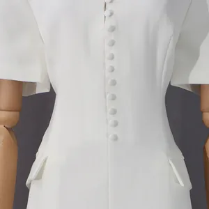 Primer plano de vestido blanco ajustado con una hilera de elegantes botones forrados en tela.