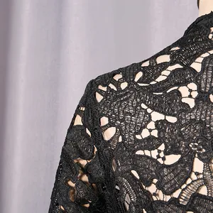 Close-up macro view showing the intricate black floral lace pattern on an elegant hollow out dress