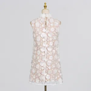 Back view of sweet white mini dress with 3D floral appliqués and pearl details on mannequin