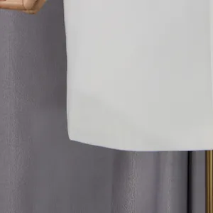 Vista detallada del dobladillo del elegante vestido blanco con textura y costura fina