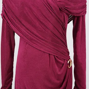 Detail of elegant wine red long sleeve dress with ruched design and gold buckle