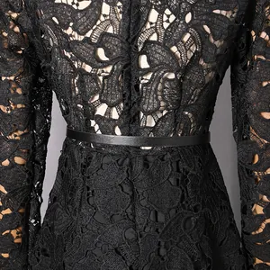 Detailed view of black hollow floral lace texture and waist belt on a slim dress