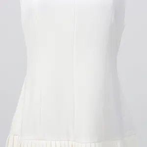 Vista detallada de la cintura entallada y el elegante dobladillo plisado de este vestido blanco.
