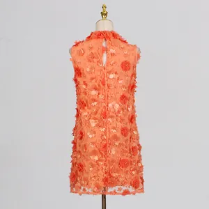 Detailed view of an orange mini dress featuring 3D flower patchwork and pearl accents