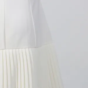Primer plano detallado del vestido blanco elegante con pliegues de acordeón finos y suaves.